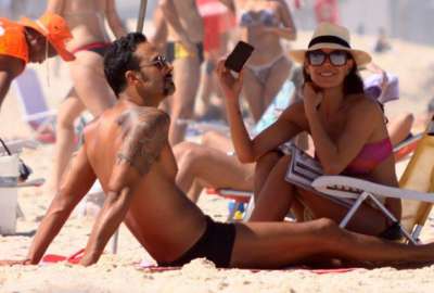 Carolina Ferraz troca carinhos com o namorado na praia