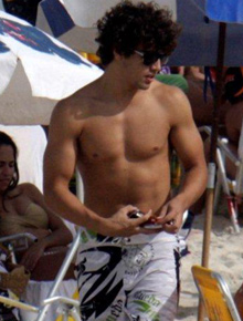Sem camisa: Caio Castro passeia na praia