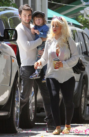 Christina Aguilera passeia com blusa semiaberta