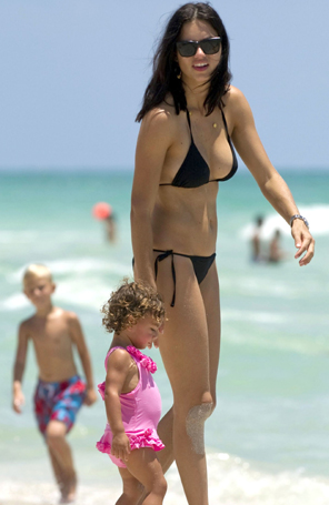 Adriana Lima é flagrada na praia com a filha