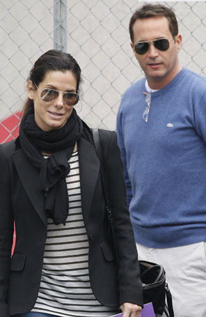 Sandra Bullock visita escola infantil em companhia masculina
