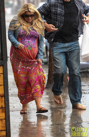 Grávida, Jessica Simpson tenta se proteger da chuva