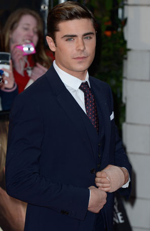 Zac Efron brinca sobre faixa em sua mão
