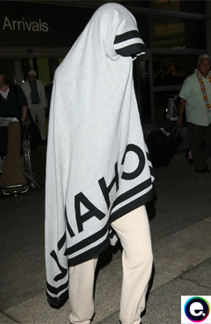 Katy Perry é flagrada no aeroporto coberta por enorme toalha