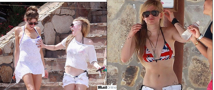 Avril Lavigne mostra boa forma e pega no seio de amiga