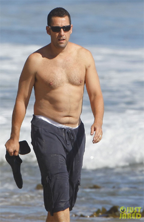 Adam Sandler exibe barriguinha em praia