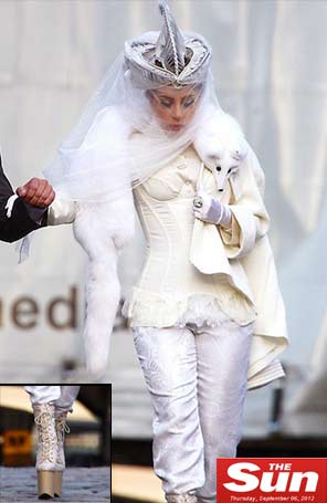 Lady Gaga é vista toda de branco e com um cachecol de pele de raposa no pescoço