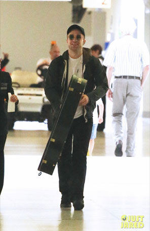 Robert Pattinson viaja com guitarra em mãos, sem Kristen Stewart
