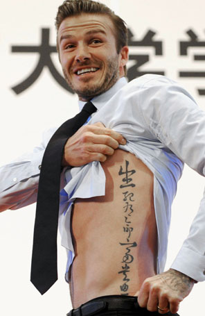 David Beckham levanta camisa e mostra a tatuagem