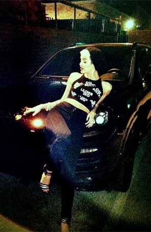 Miley Cyrus posa em cima de carro