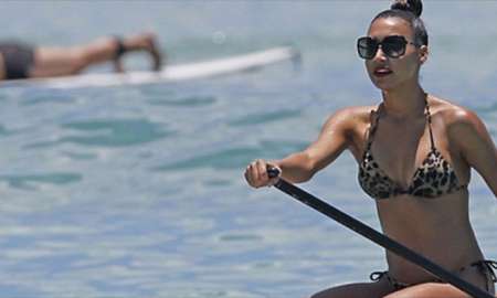 Naya Rivera rema em prancha de surfe no mar