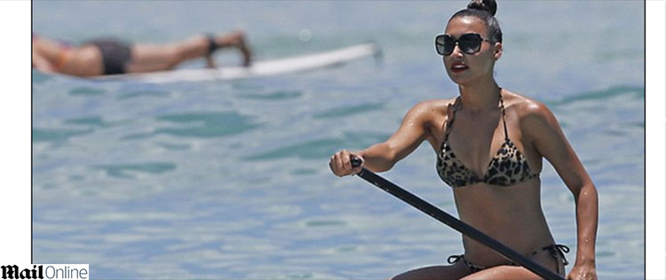 Naya Rivera rema em prancha de surfe no mar