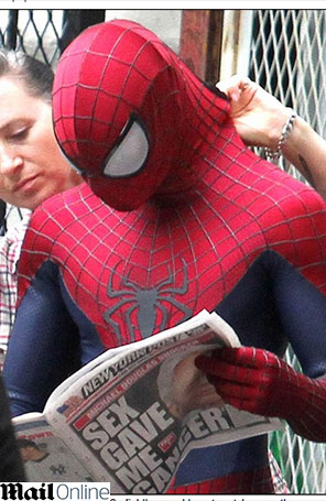 Usando figurino do Homem-Aranha, Andrew Garfield lê o jornal