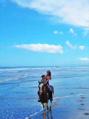 Gisele Bündchen anda a cavalo na praia com o filho