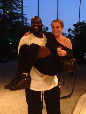 Sorridente, Lindsay Lohan é fotografada sendo carregada por ex-jogador de basquete