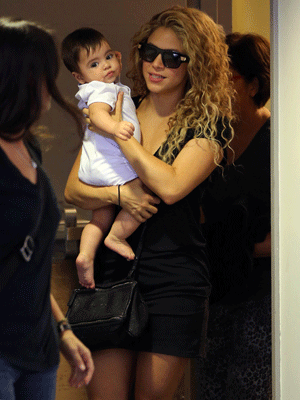 De vestido curto e Milan no colo, Shakira é flagrada em aeroporto