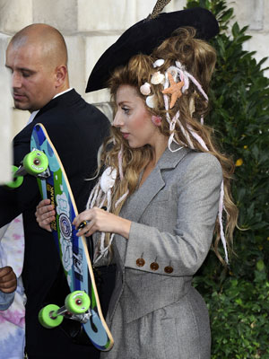 Lady Gaga usa conchas no cabelo e carrega <i>skate</i>