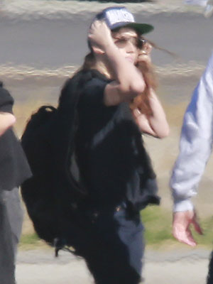 Kristen Stewart quase perde o boné ao embarcar em avião