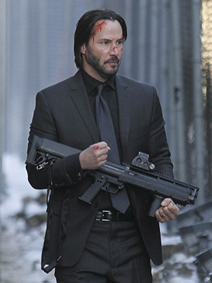 Keanu Reeves empossa arma e aparece ensanguentando em <i>set</i> de filmagens