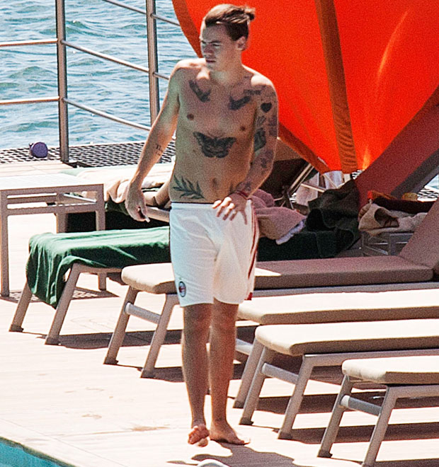 Harry Styles aparece sem camisa e exibe tatuagens à beira da piscina