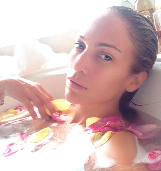 Jennifer Lopez relaxa na banheira, sem maquiagem