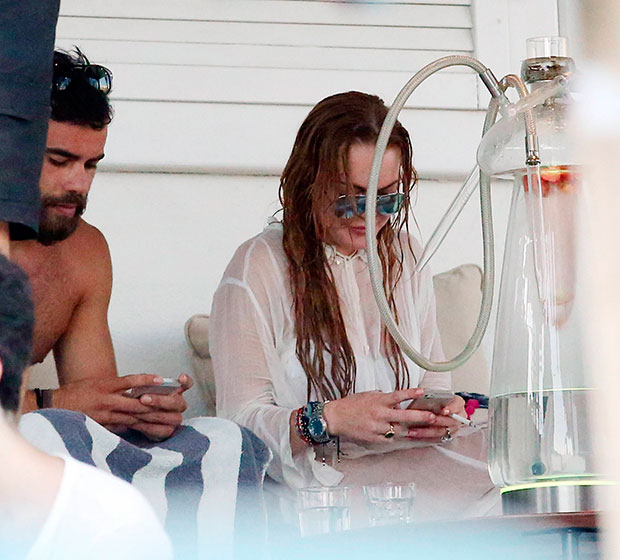 Lindsay Lohan exibe aliança ao lado de moreno misterioso