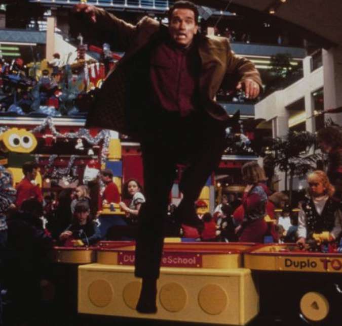Arnold Schwarzenegger ficou conhecido por suas investidas na comédia, e acabou em uma destas aventuras tentando agradar as bilheterias natalinas. Em Um Herói de Brinquedo, o vendedor de colchões Howard Langston se atrasa para a aula de karatê do seu filho Jamie. Para consertar as coisas com o garoto, ele pergunta a Jamie o que ele mais gostaria de ganhar no Natal. A partir daí, Howard parte em uma busca cheia de confusões pelo presente ideal para o filho.