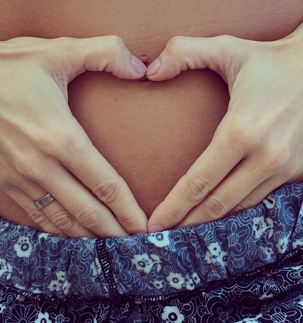 Grávida, Deborah Secco faz coração com as mãos ao ter a barriga fotografada pelo namorado