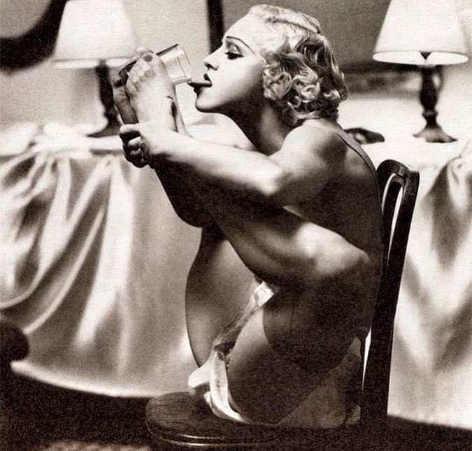 Madonna mostra flexibilidade e leva um copo até a boca com o pé