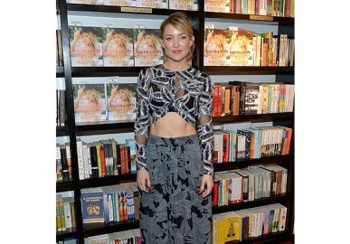 Kate Hudson deixa barriga torneada à mostra durante lançamento de seu livro