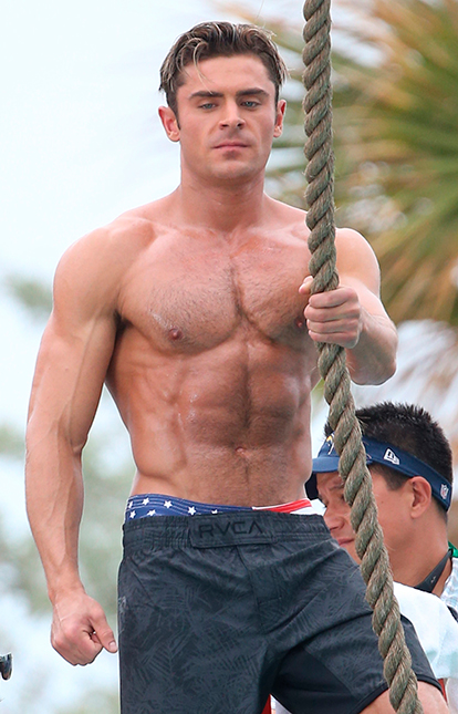 Zac Efron exibe corpão sarado e grava cenas românticas no <i>set</i> de <I>Baywatch</i>
