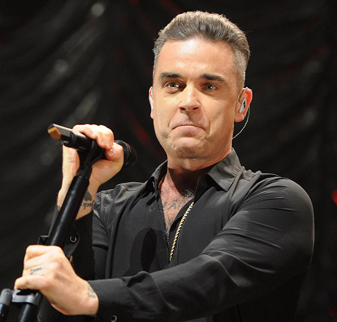 Robbie Williams passa álcool em gel nas mãos após tocar em fãs durante <I>show</I>, veja!