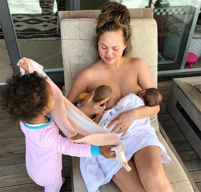 Chrissy Teigen brinca ao amamentar seu filho recém-nascido e uma boneca: <i>Acho que tenho gêmeos agora</i>