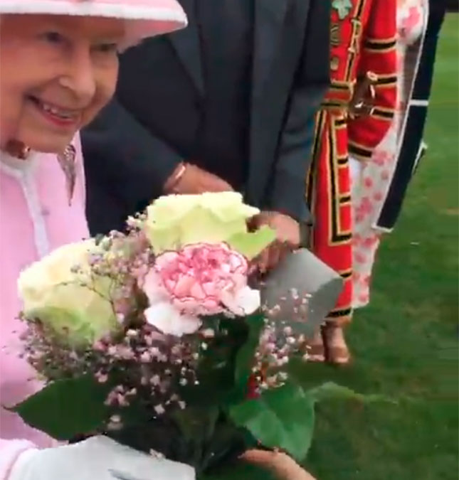 Assim como Meghan Markle, Rainha Elizabeth II quebra protocolo e pega presente com as mãos