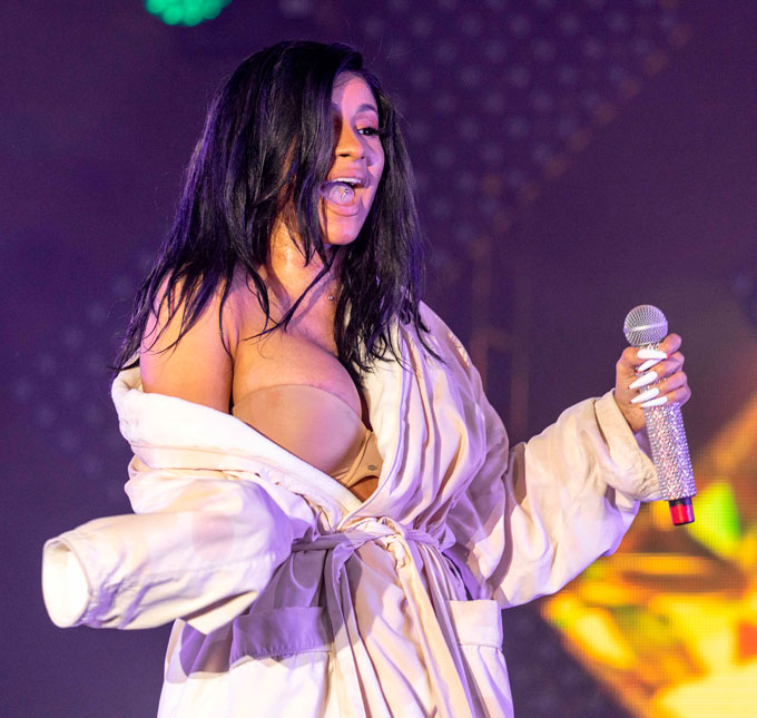 Cardi B exagera no rebolado, rasga figurino no bumbum e fica de roupão no palco