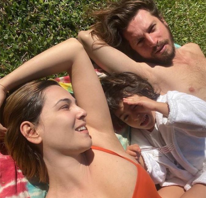 Tainá Müller renovou o bronzeado com uma peça laranja ao deitar ao lado do marido, Henrique Sauer, e do filho, Martin, para tomar sol.