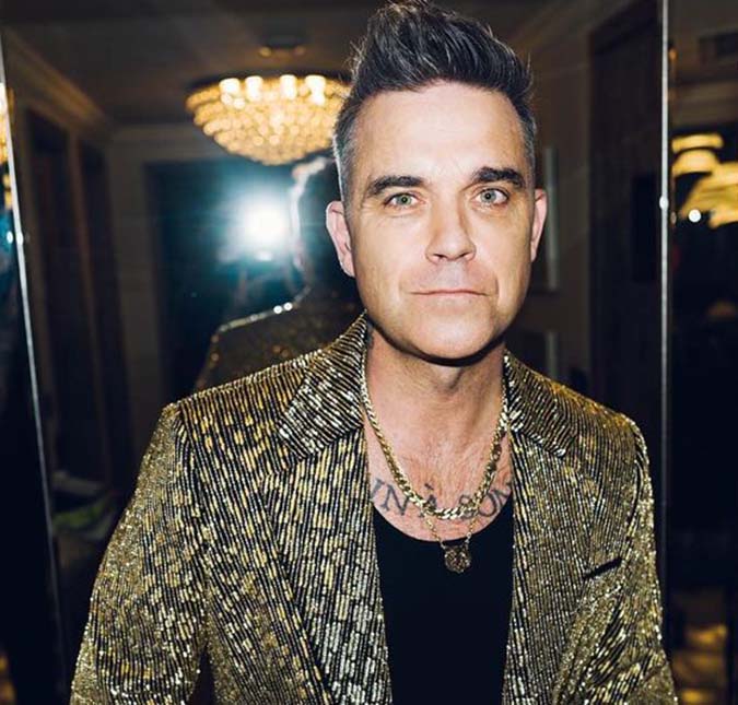 Robbie Williams revela frustração por perda de cabelo: -<i>Quando a luz bate, minha cabeça fica parecendo um bumbum de bebê</i>