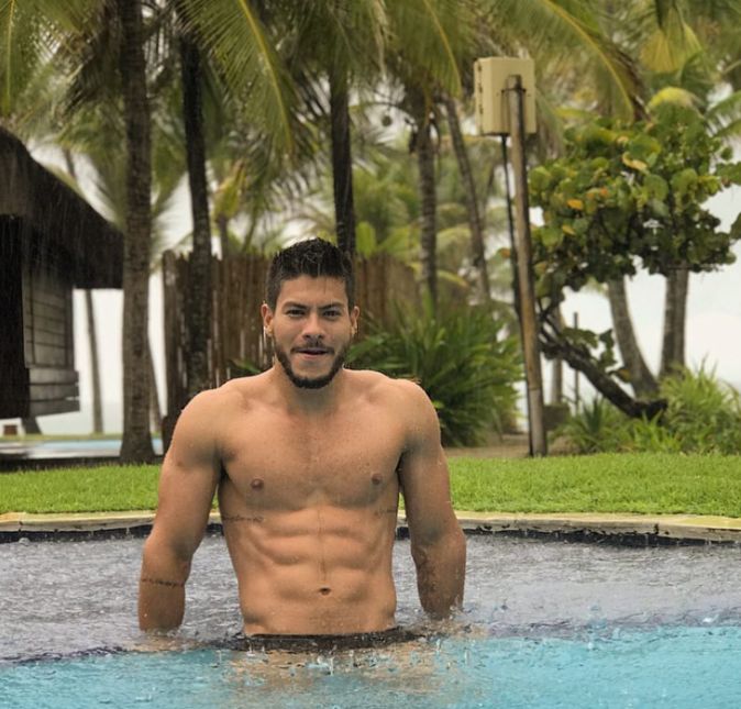 Mesmo enfrentando uma chuvinha, o ator fez questão de posar na borda de uma piscina e ostentar o tanquinho.