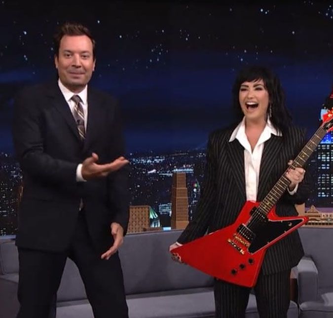 Demi Lovato ganha guitarra de presente de aniversário de Jimmy Fallon; assista! A cantora participou do The Tonight Show para divulgar seu novo álbum, Holy Fvck