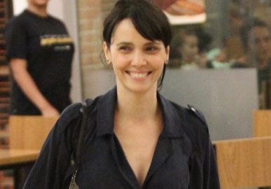 De mãos dadas e sorridente, Débora Falabella passeia com o namorado no Rio de Janeiro