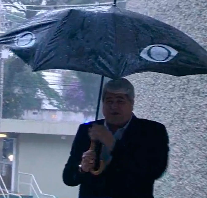 Datena fica todo molhado após guarda-chuva quebrar ao vivo: - <i>Acho que vou ter que trocar de roupa</i>