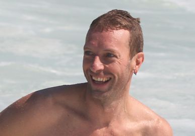 Chris Martin curte praia no Rio de Janeiro e exibe corpo definido