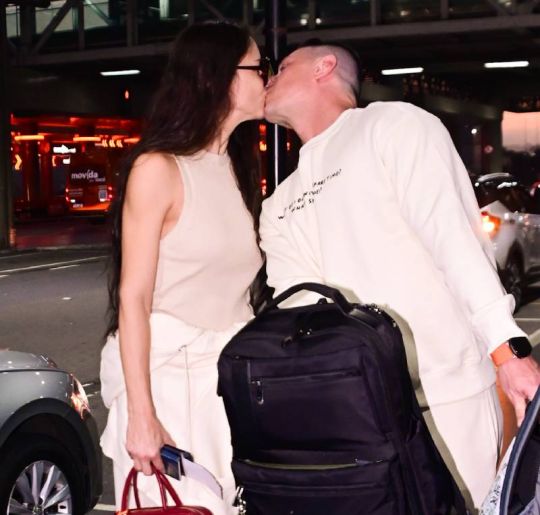 Em clima de romance, Adriana Lima desembarca no Brasil ao lado do marido e troca beijos apaixonados