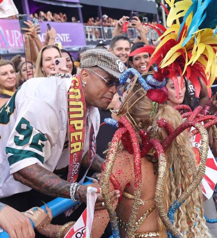 Fã número um! Léo Santana se derrete por Lore Improta e usa faixa de <i>campeão</i> em desfile das campeãs do Rio de Janeiro